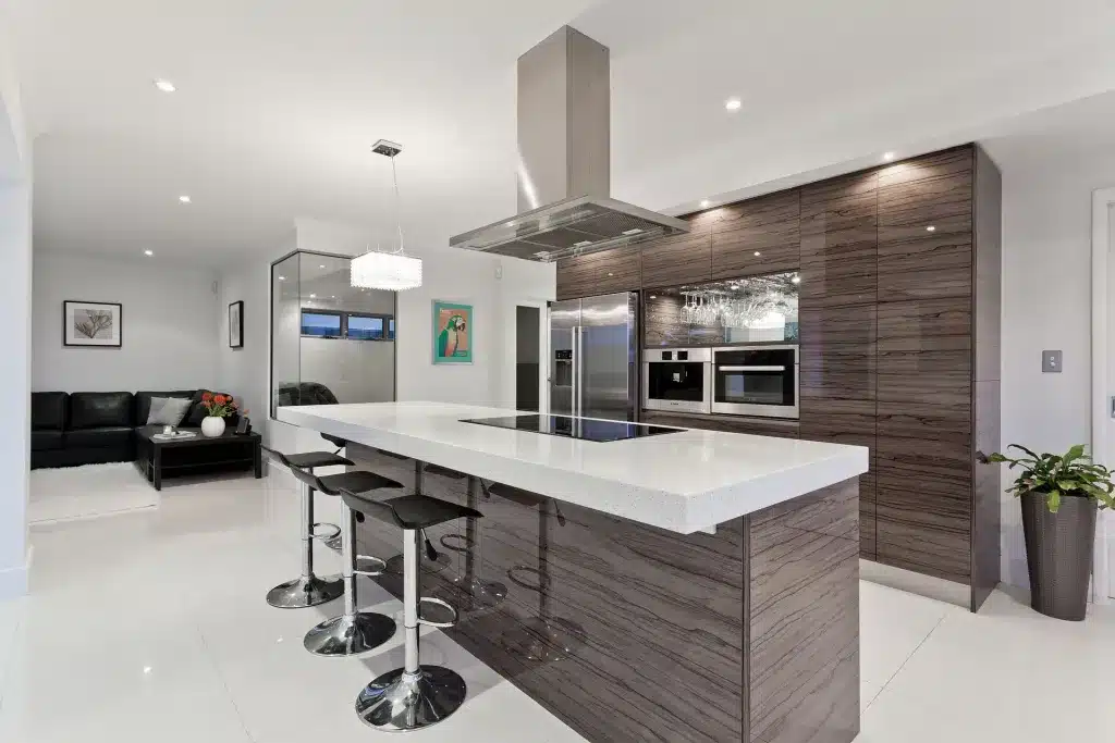 Modern open-plan kitchen with sleek design, large island, and integrated stainless steel appliances.