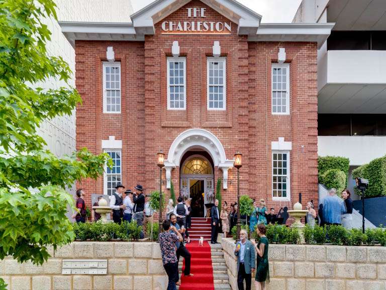 The Charleston: historic red-brick venue hosting diverse, stylish social event with modern urban backdrop.