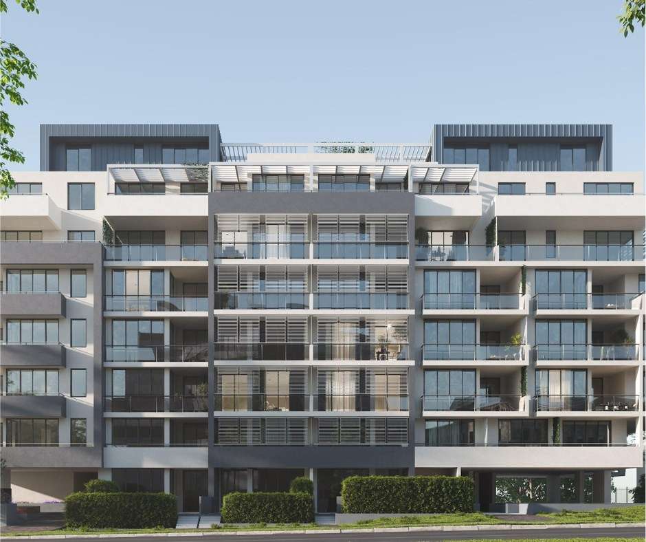Modern apartment building with glass windows, balconies, greenery, and contemporary architectural design.