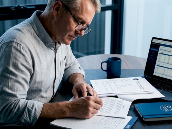 Man reviewing SMSF property documents at home